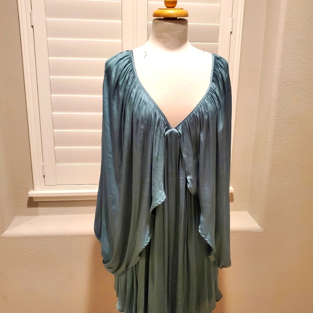 Green dress with deep v neck design with draping detail in the front and back.